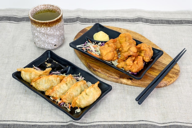 Karaage kip gefrituurd met Gyoza dumplings en hete thee op doek