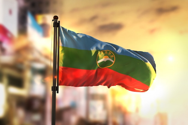 Karachay-Cherkessia Vlag Tegen Stad Wazige Achtergrond Bij Zonsopgang Achtergrondverlichting