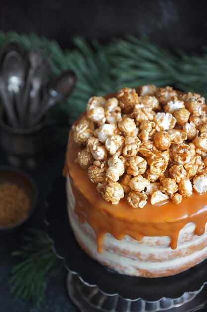 Karamel feesttaart met popcorn op een donkere achtergrond, Selectieve aandacht, Close-up, Verticaal, Kerstfeest