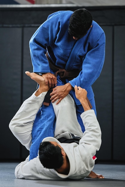 Photo karate fitness and exercise of a student training with a coach and learning in a contact sport man with personal trainer in martial arts sports fight for safety wellness and health in a gym