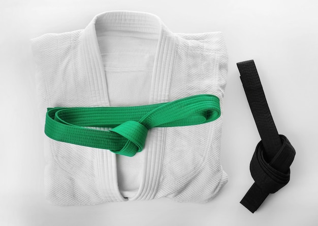 Foto uniforme da karate con cinture nere e verdi su sfondo bianco