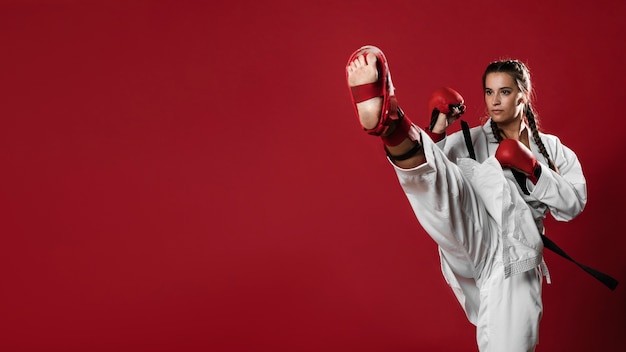 Karate woman in action isolated in red background