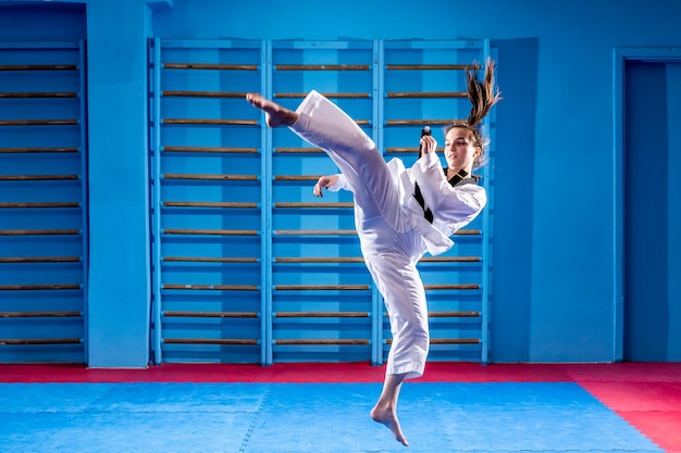 The karate woman with black belt Sport woman fighting poses punch in sport uniform dress Taekwondo karate