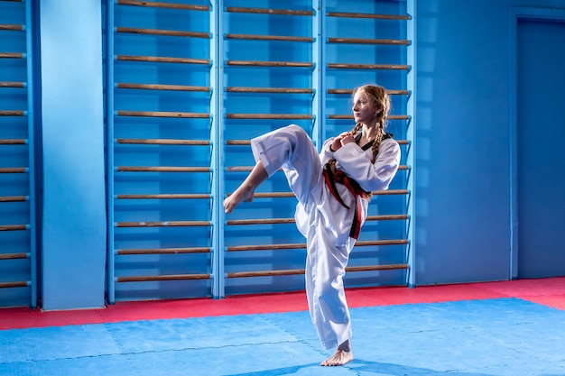 The karate woman with black belt Sport woman fighting poses punch in sport uniform dress Taekwondo karate