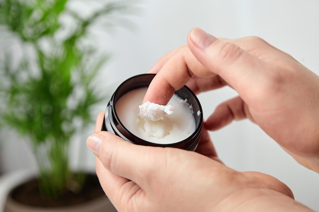 Karitéboter natuur cosmetische crème voor haarverzorging in pot in vrouw hand close-up