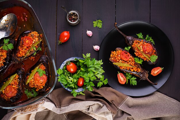 Karniyarik - turkse traditionele aubergineaubergine maaltijd. gevulde aubergines met rundergehakt en groenten gebakken met tomatensaus. turkse keuken. bovenaanzicht kopieer ruimte