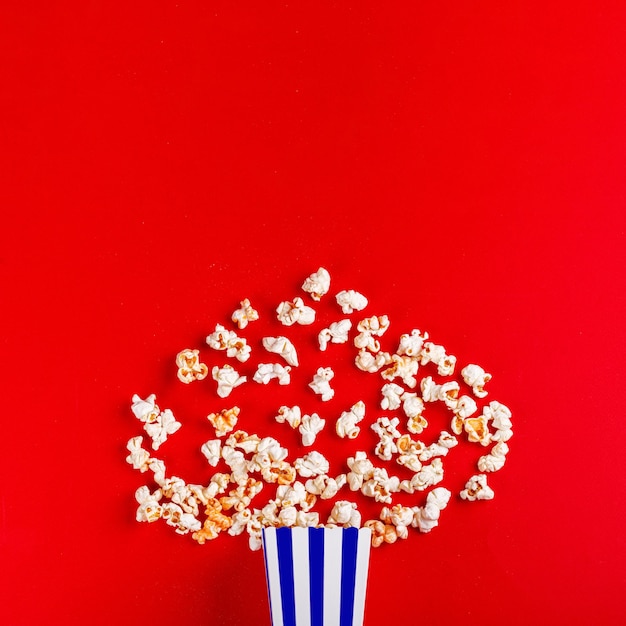 kartonnen doos met popcorn op een rode achtergrond close-up