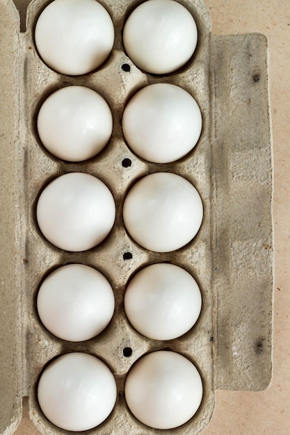 Kartonnen eierrek met eieren op rustieke achtergrond met kopieerruimte voor tekst