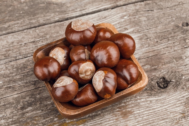 Kastanjes op een oude houten tafel.