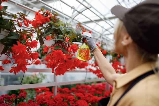 Kaswerker vrouw bloemen sproeien