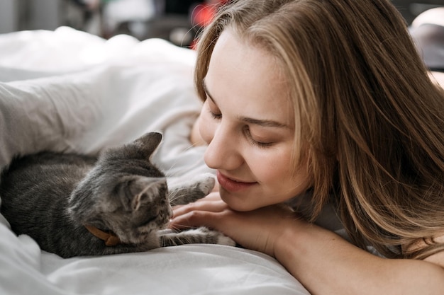 Katadoptie adopteert kitten uit reddings- en opvangcentra herplaats een kattenportret van een spelende vrouw