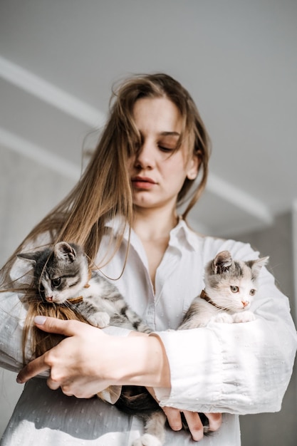 Katadoptie adopteert kitten uit reddings- en opvangcentra portret van vrouw die speelt met twee gekruiste dieren