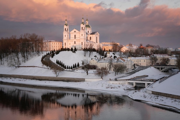 Kathedraal van de Heilige Hemelvaart aan de oevers van de westelijke Dvina-rivier op een zonnige winterdag in Vitebsk, Wit-Rusland