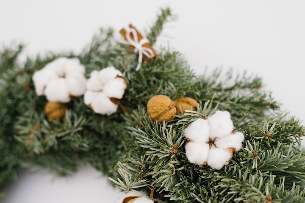 Katoenen bloem en okkernoten in Kerstmiskroon, close-up van kroon