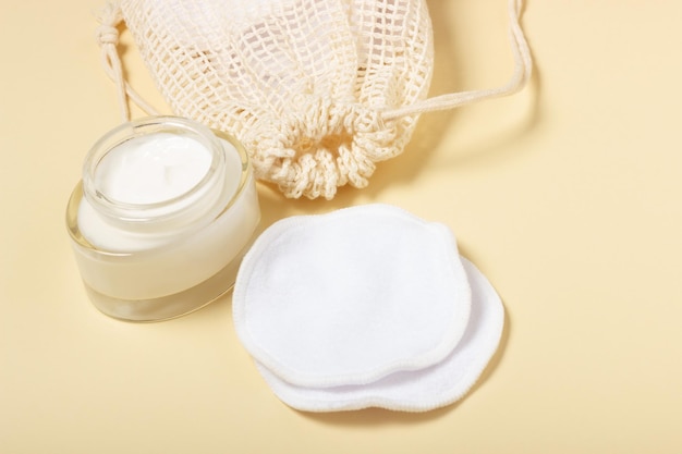 Katoenen herbruikbare make-up remover pads in een stoffen zak op een beige achtergrond Het concept van ecologie en bewuste consumptie Herbruikbare wattenschijfjes