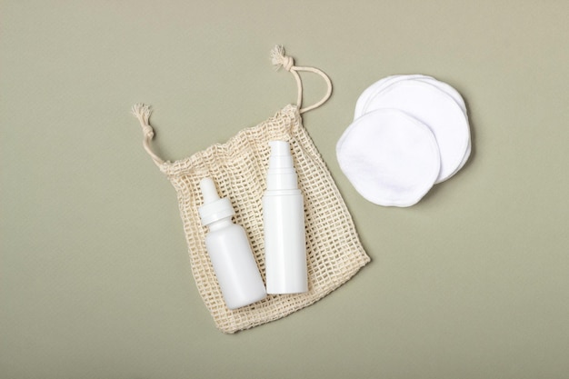 Katoenen herbruikbare make-up remover pads in een stoffen zak op een beige achtergrond Het concept van ecologie en bewuste consumptie Herbruikbare wattenschijfjes