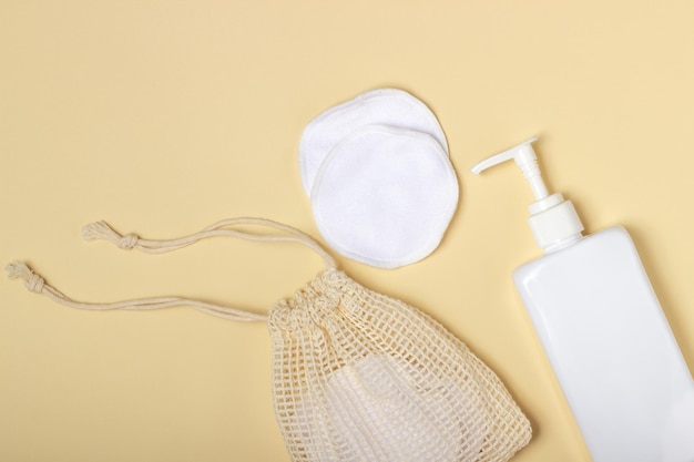 Katoenen herbruikbare make-up remover pads in een stoffen zak op een beige achtergrond Het concept van ecologie en bewuste consumptie Herbruikbare wattenschijfjes