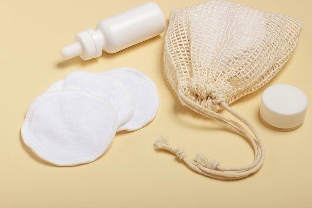 Katoenen herbruikbare make-up remover pads in een stoffen zak op een beige achtergrond het concept van ecologie en bewuste consumptie herbruikbare wattenschijfjes