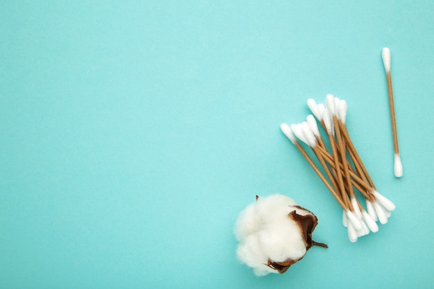 Katoenen oorstokken met bloem op geïsoleerd blauw