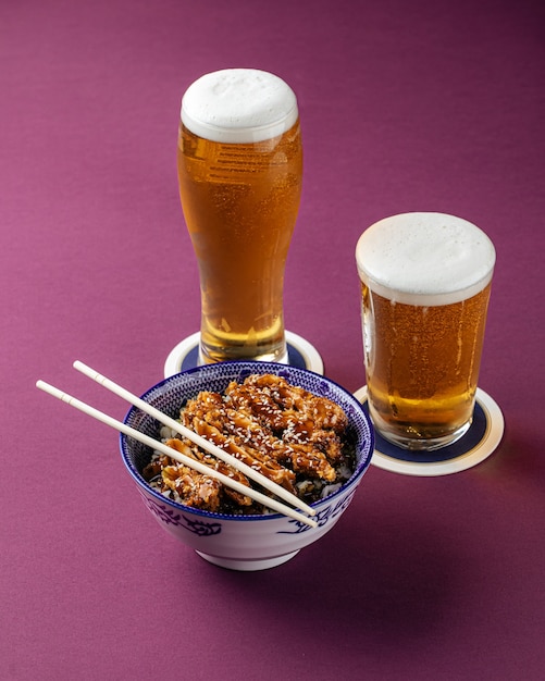 Foto katsudon kiprijst met bier op paarse achtergrond