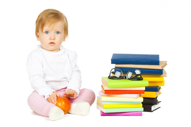 Kaukasisch babymeisje met stapel boeken die op wit worden geïsoleerd