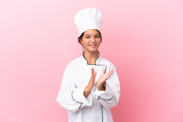 Kaukasisch chef-kokmeisje geïsoleerd op roze achtergrond applaudisseren na presentatie in een conferentie