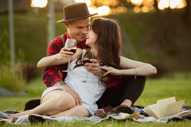 Kaukasisch jong en gelukkig stel genieten van een picknick in het park op zomerdag