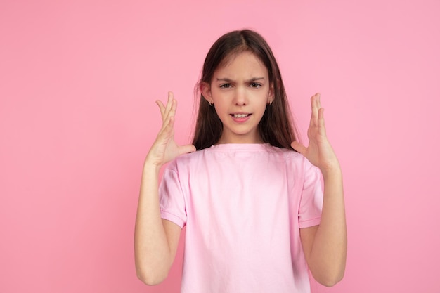 Kaukasisch klein meisje portret geïsoleerd op roze studio achtergrond, emoties concept