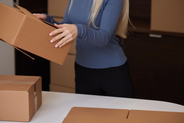 Kaukasisch meisje dat dozen plakt om in een nieuw appartement te verhuizen