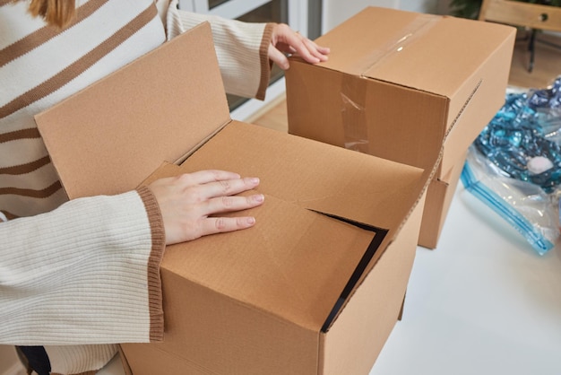 Kaukasisch meisje dat dozen plakt om in een nieuw appartement te verhuizen