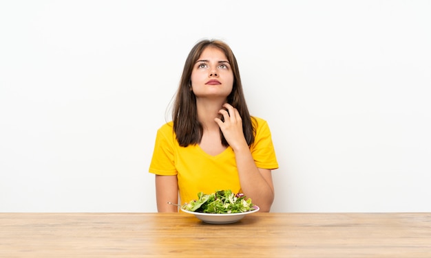 Kaukasisch meisje dat met salade een idee denkt