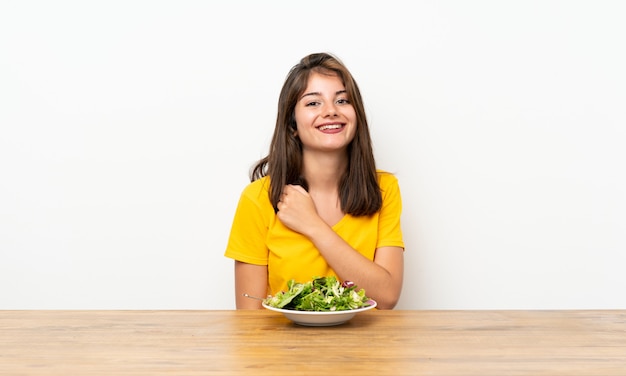 Kaukasisch meisje dat met salade een overwinning viert