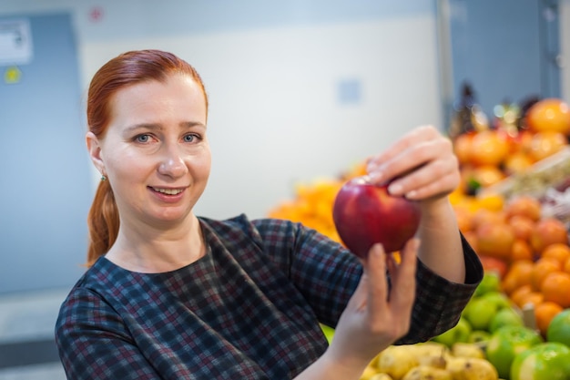 Kaukasisch meisje dat voedselproducten met verse groenten koopt op de marktxA