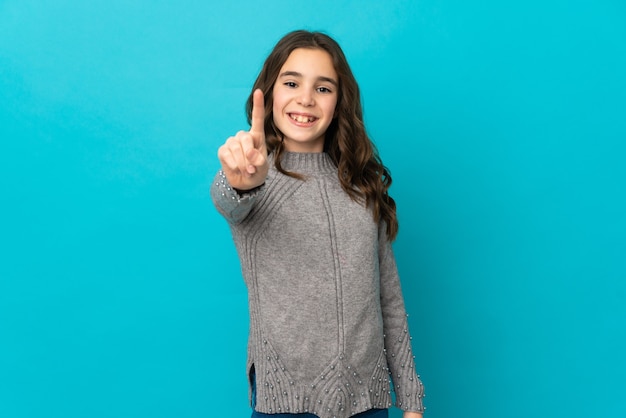Kaukasisch meisje geïsoleerd op een blauwe achtergrond die een vinger laat zien en optilt