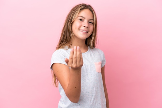 Kaukasisch meisje geïsoleerd op een roze achtergrond die uitnodigt om met de hand te komen Blij dat je bent gekomen