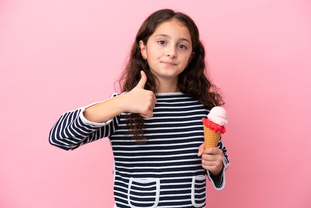 Kaukasisch meisje met een ijsje geïsoleerd op een roze achtergrond met een duim omhoog gebaar