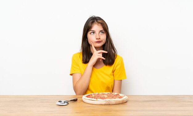 Kaukasisch meisje met een pizza die een idee denkt