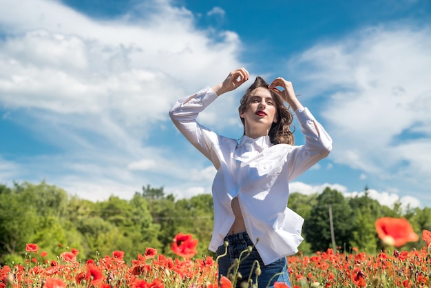 Kaukasisch model geniet van het leven op papaverveld, zonnige dag. gezondheid levensstijl