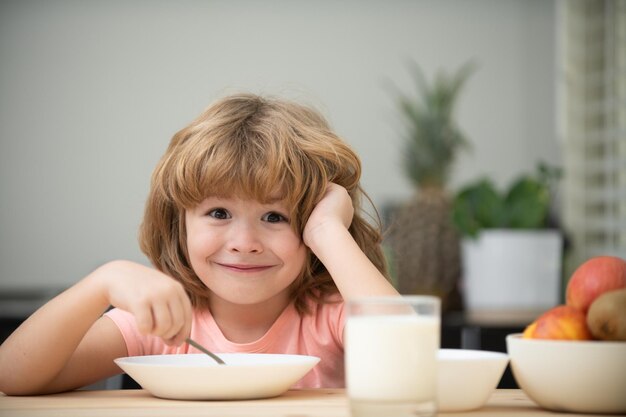 Kaukasisch peuterkind dat gezond soepkind eet met een lepel en een bord in de keuken thuis