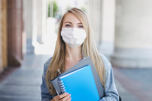 Kaukasisch studentenmeisje dat een medisch masker draagt