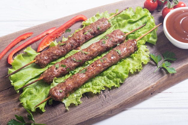 Kaukasisch traditioneel eten Shish kebab of lulakebab met groenten en saus