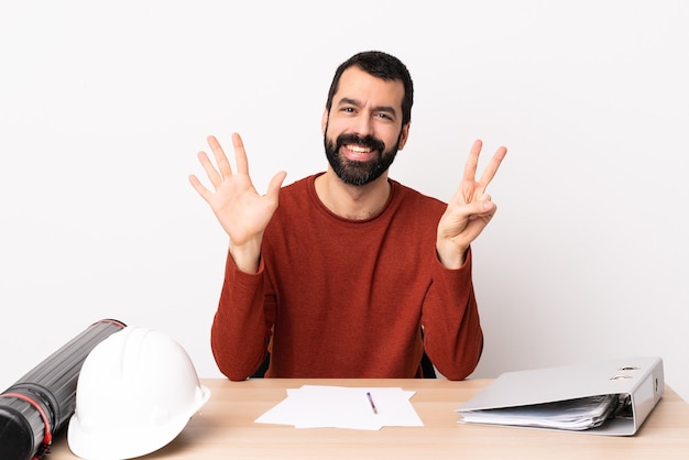 Kaukasische architectenmens met baard in een lijst die zeven met vingers telt.