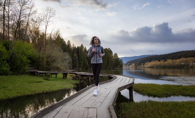 Kaukasische atletische vrouw die op een houten pad door een moeras loopt in Shoreline Trail