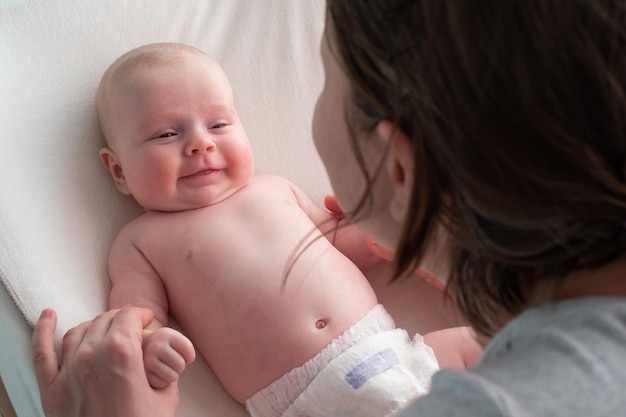 Kaukasische baby die lachend naar zijn moeder kijkt