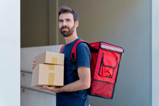 kaukasische bezorger die pakketdoos levert. Koerier dienstverleningsconcept. horizontale weergave van gelukkige rijder die een pakket thuis bezorgt.