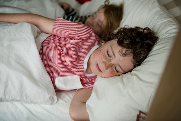 Kaukasische broers en zussen die op het bed slapen