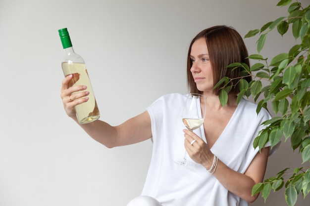 Kaukasische brunette meisje sommelier glas witte wijn te houden