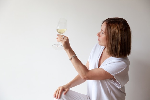 Kaukasische brunette meisje sommelier glas witte wijn te houden