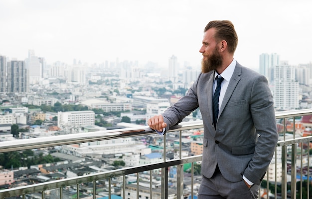 Kaukasische Business Man Standing leuningen uitzicht op de stad