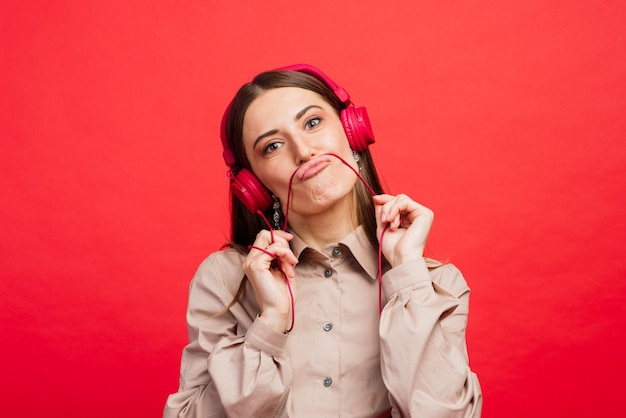 Kaukasische emotionele vrouw die aan muziek in hoofdtelefoons luistert